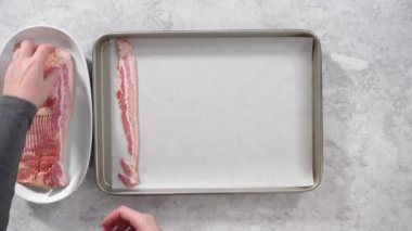 Time lapse. Flat lay. Step by step. Uncooked bacon strips on a baking sheet with white parchment paper.