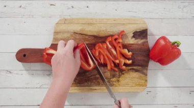 Düz yatıyordu. Ağaç kesme tahtasında organik kırmızı dolma biber kesiyorum..