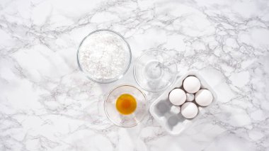 Adım adım. Düz yatıyordu. Tek boynuzlu at meringue kurabiyesi yapmak için cam bir kasenin içindeki malzemeler..