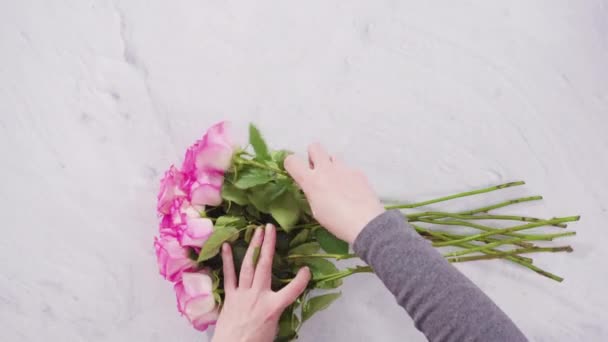 平躺在床上一步一步 花匠用粉红的玫瑰整理花束 — 图库视频影像