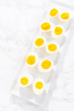 Beyaz servis tabağında dilimlenmiş haşlanmış yumurta..