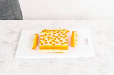 Beyaz bir kesme tahtasının üzerinde şekerli mısır şekerini kare parçalara ayırmak..