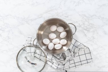 Haşlanmış yumurta pişirmek için tencerede beyaz yumurta kaynatmak..