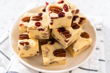 Beyaz seramik tabakta ev yapımı beyaz çikolatalı fındıklı şekerleme parçaları..