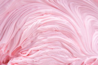 Manzarayı kapat. Vanilyalı kremanın içine pembe gıda boyası karıştırarak funfettti desenli pastayı süslemek için..