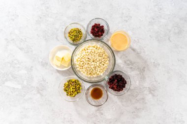 Düz yatıyordu. Kızılcık fıstıklı şekerleme hazırlamak için cam karıştırma kabında ölçülmüş malzemeler..