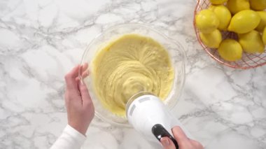 Düz yatıyordu. Adım adım. Limonlu kek hazırlamak için karıştırma kabındaki malzemeleri karıştırıyorum..