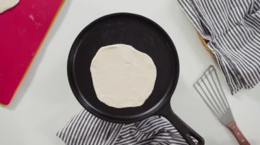 Düz yatıyordu. Dökme demir tavada ev yapımı ekmek hazırlıyorum..