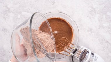 Düz yatıyordu. Adım adım. Kırmızı kadife kek hazırlamak için karıştırma kabındaki malzemeleri karıştırıyorum..