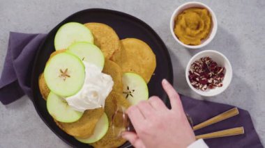 Adım adım. Düz yatıyordu. Siyah servis tabağında yeşil elmalı taze yapılmış balkabağı gözlemeleri..