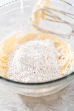 Havuçlu kek için krem peynirli pasta yapmak için malzemeleri büyük bir karıştırma kabında karıştırıyorum..