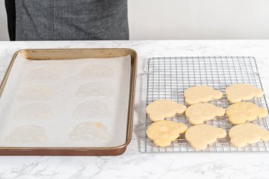 Cooling panda-shaped shortbread cookies on a cooling rack at the kitchen counter.