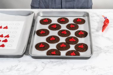 Çikolatalı kurabiyeleri kırmızı çikolatalı kalplerle süslüyor..