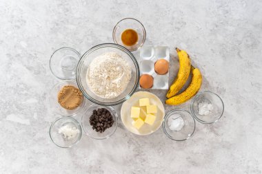 Düz yatıyordu. Muzlu kurabiyeleri çikolatalı çiselemeyle karıştırmak için bardaktaki ölçülü malzemeler..