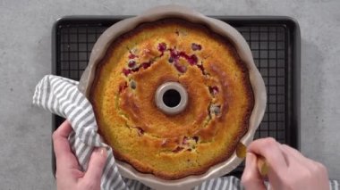 Time lapse. Flat lay. Step by step. Cooling lemon cranberry bundt cake on the kitchen wire rack.