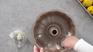 Time lapse. Flat lay. Step by step. Greasing bundt cake pan to bake lemon cranberry bundt cake.