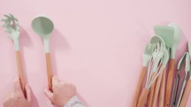 Düz yatıyordu. Pembe arka planda ahşap saplı yeni mavi silikon mutfak aletleri..
