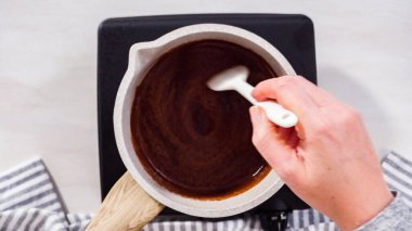 Adım adım. Düz yatıyordu. Elektrikli bir tavanın üzerinde küçük bir tencereyle çikolata kreması hazırlıyorum..