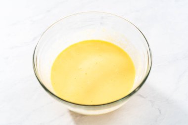 Kırmızı kadife kek ve krem peynir jöleli kek yapmak için büyük bir bardakta karıştırma malzemesi..