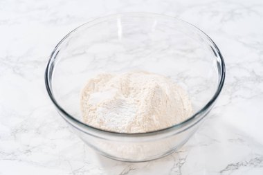 Kuru malzemeleri, büyük bir bardakta çırpma kabıyla karıştırarak Amerikan bayrağı mini kekleri pişiriyor..