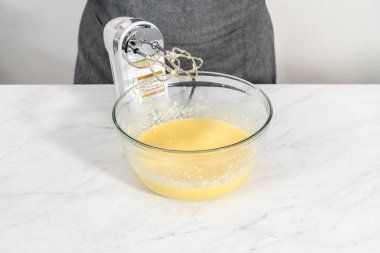 Kırmızı kadife kek ve krem peynir jöleli kek yapmak için büyük bir bardakta karıştırma malzemesi..