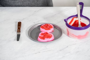 Sevgililer Günü 'nde çikolata dudaklar ve kalp şeklinde çikolatalar yapmak için silikon kalıbı erimiş çikolatayla dolduruyorum..