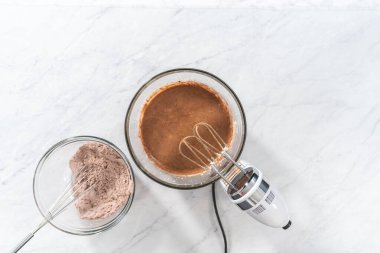 Düz yatıyordu. Kırmızı kadife kek ve krem peynir jöleli kek yapmak için büyük bir bardakta karıştırma malzemesi..