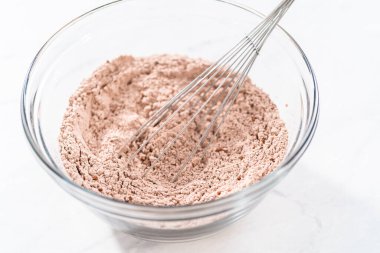 Kırmızı kadife kek ve krem peynir jöleli kek yapmak için büyük bir bardakta karıştırma malzemesi..