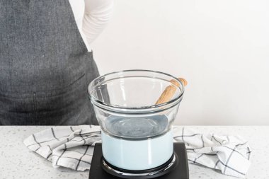 Çikolata parçacıkları ve diğer malzemeleri kaynayan suyun üzerine karıştırıp kabak aromalı şekerleme hazırlıyorum..