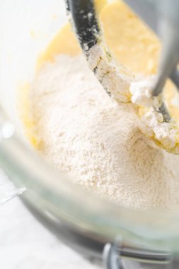 Mixing ingredients in kitchen electric mixer to bake American flag mini cupcakes.