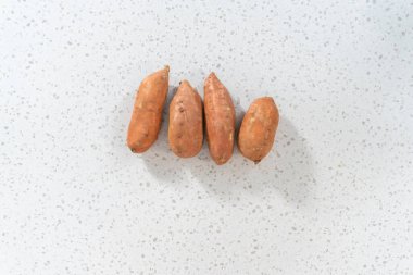 Düz yatıyordu. Fırında kızartılmış tatlı patates yapmak için cam karıştırma kabında ölçülmüş malzemeler..