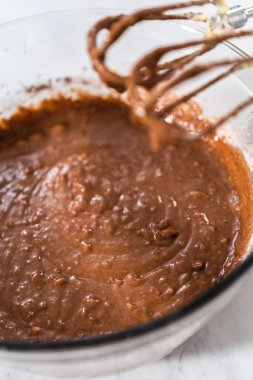 Kırmızı kadife kek ve krem peynir jöleli kek yapmak için büyük bir bardakta karıştırma malzemesi..