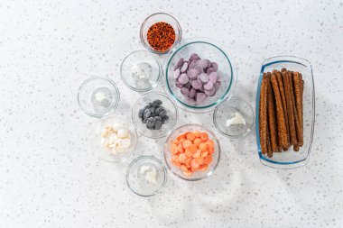 Düz yatıyordu. Cadılar Bayramı 'nda çikolata kaplı çubuk çubuk kraker yapmak için cam karışımında ölçülmüş malzemeler..