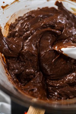 Beyaz çikolata parçacıkları ve diğer malzemeleri kaynayan suyun üzerine karıştırıp çikolatalı macadamia şekerlemesi hazırlıyorum..