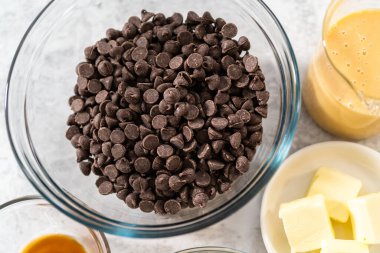 Çikolatalı macadamia şekerlemesi yapmak için cam karıştırma kabında ölçülmüş malzemeler..