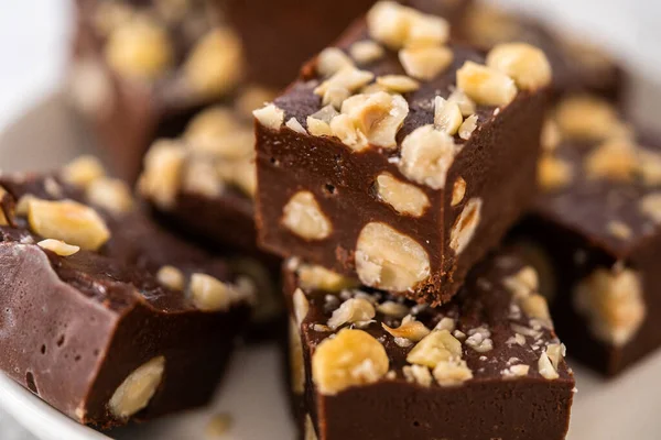 stock image Homemade chocolate hazelnut fudge square pieces on a white plate.