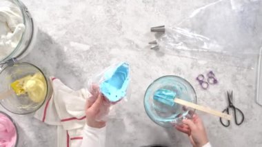 Zaman aşımı. Düz yatıyordu. Adım adım. Tek boynuzlu at meringue kurabiyesi pişirmek için metal uçlu boru torbalarına krema karıştırılıyor..