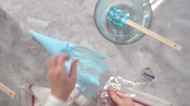 Düz yatıyordu. Adım adım. Tek boynuzlu at meringue kurabiyesi pişirmek için metal uçlu boru torbalarına krema karıştırılıyor..