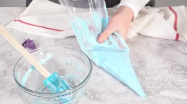Adım adım. Tek boynuzlu at meringue kurabiyesi pişirmek için metal uçlu boru torbalarına krema karıştırılıyor..