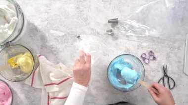 Düz yatıyordu. Adım adım. Tek boynuzlu at meringue kurabiyesi pişirmek için metal uçlu boru torbalarına krema karıştırılıyor..