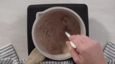 Adım adım. Düz yatıyordu. Elektrikli bir tavanın üzerinde küçük bir tencereyle çikolata kreması hazırlıyorum..