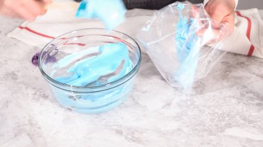 Adım adım. Tek boynuzlu at meringue kurabiyesi pişirmek için metal uçlu boru torbalarına krema karıştırılıyor..