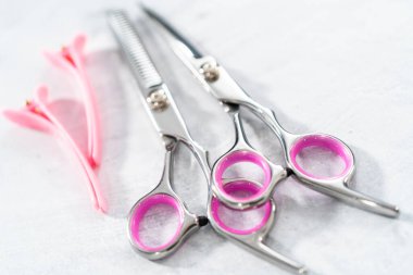 Gri arkaplanda yeni berber pembe makas.