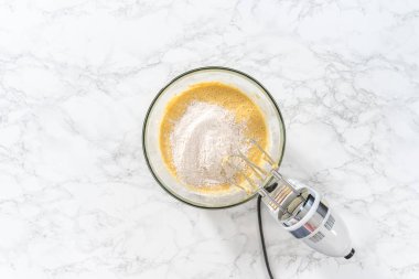 Düz yatıyordu. Malzemeleri karıştırıcı ile karıştırarak büyük bir karıştırma kabında yumurta likörü pişirmek..