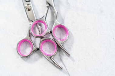 Gri arkaplanda yeni berber pembe makas.