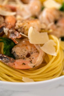 Beyaz seramik kaselerde ıspanaklı sarımsaklı karides makarnası servis ediyorum..