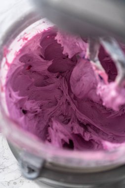 Mutfaktaki elektrikli mikserin içeriğini karıştırıp tereyağlı krema yapıyorum..