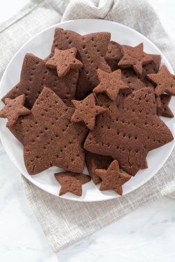 Beyaz tabakta taze pişmiş yıldız şeklinde çikolatalı kraker..