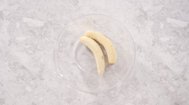 Düz yatıyordu. Adım adım. Hindistan cevizli muzlu krep hazırlamak için kırık muzları cam bir kasede kırıyorlar..