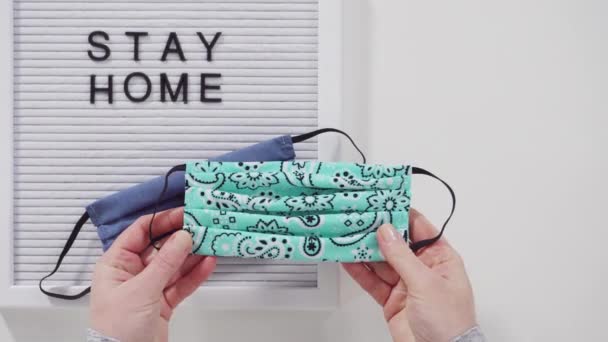 Stay Home Schild Auf Der Anzeigetafel Mit Einer Hausgemachten Gesichtsmaske — Stockvideo